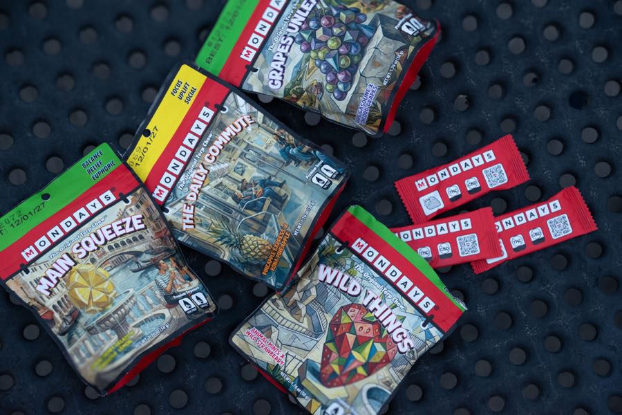 MONDAYS pouches and individually wrapped terpene chews laid out on a dark surface.